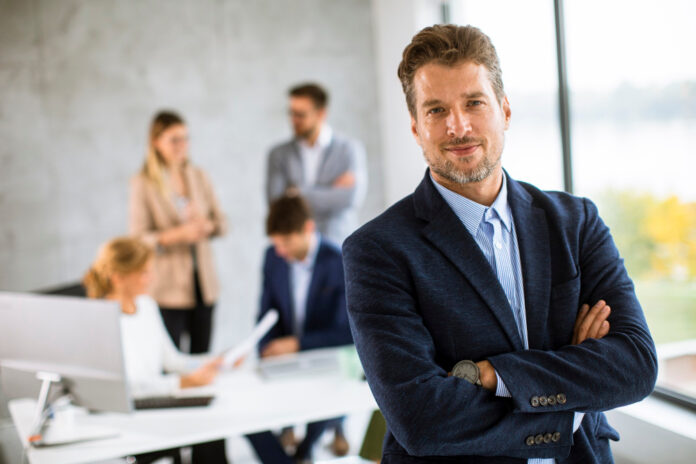 handsome-young-business-man-standing-confident-office-front-his-team